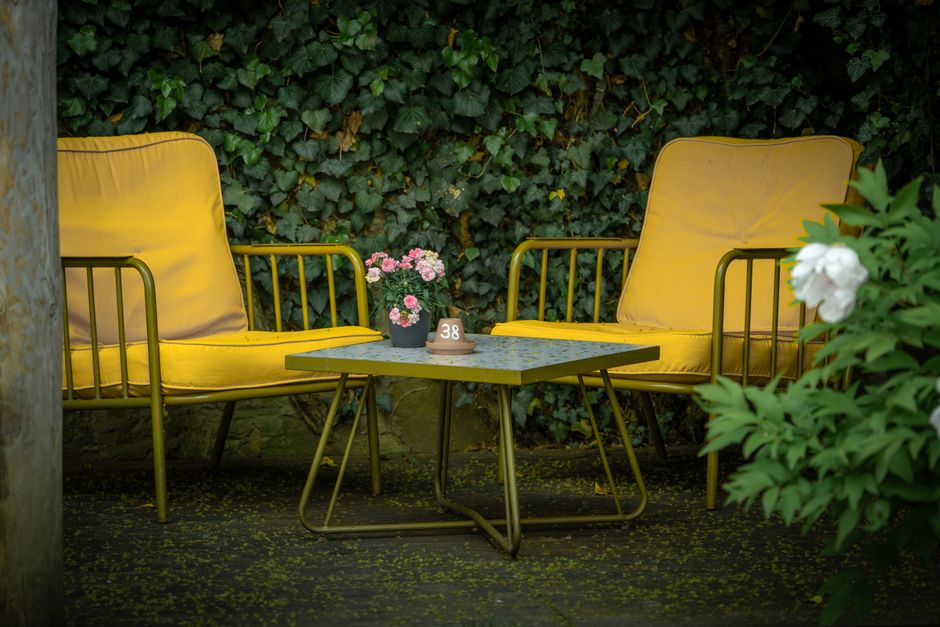 Gezellige zithoek buiten met zachte lichtjes voor 'hygge'.